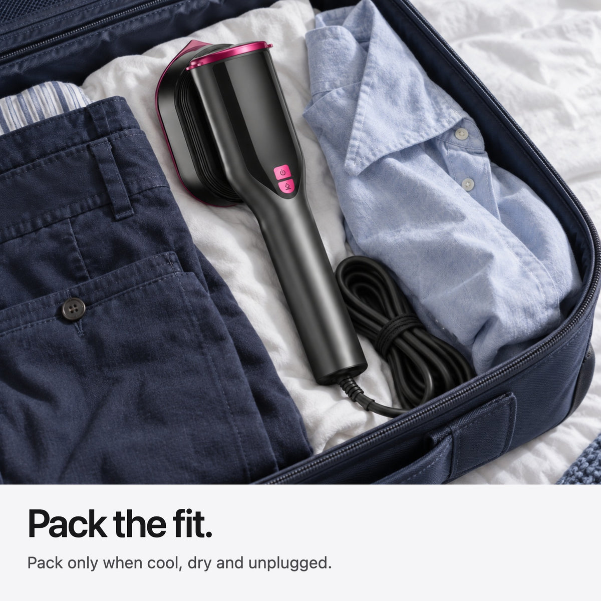 Cooled Carter & Cole steamer and attached cable packed with cotton clothes in navy luggage